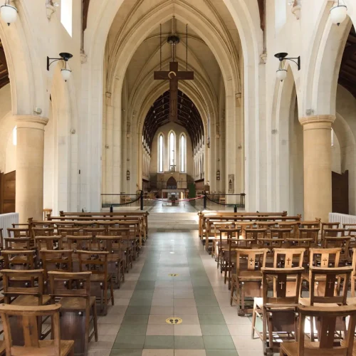 Image of the Mount St Bernard Abbey interior. Alter, pews, and crucifix handing from ceiling