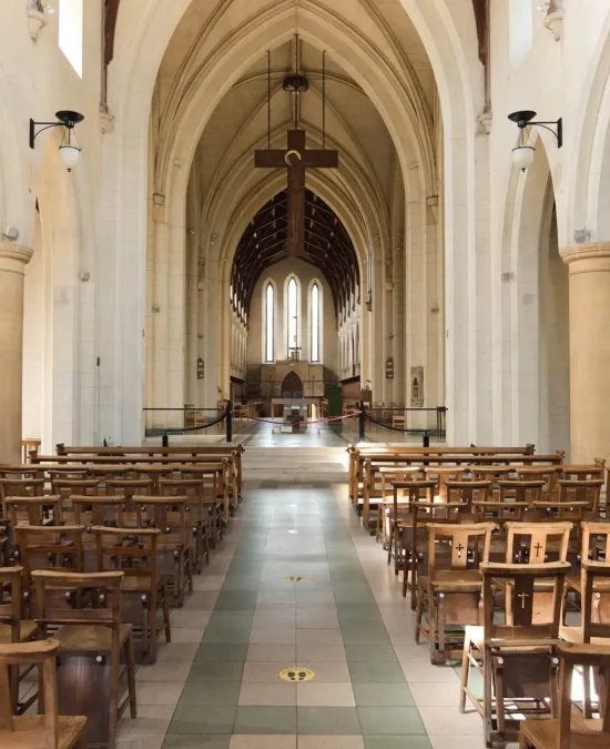 Image of the Mount St Bernard Abbey interior. Alter, pews, and crucifix handing from ceiling