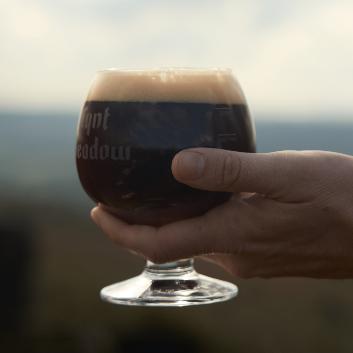 Tynt Meadow in branded glass, beautifully poured close up of hand